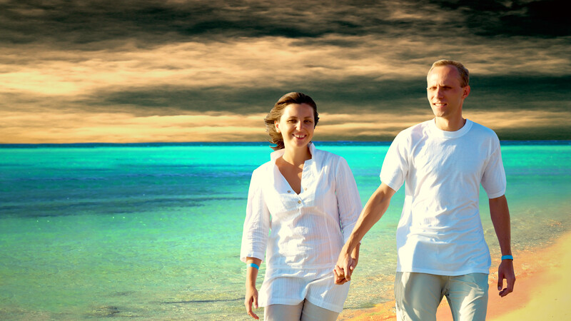 marriage succeed: happy couple walking on clouded beach