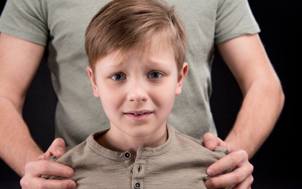 parental kidnapping: worried young boy standing in front of dad