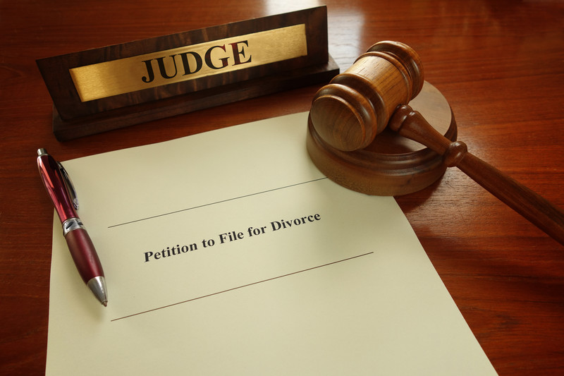 filing for divorce: a divorce petition surrounded by a name plate and gavel