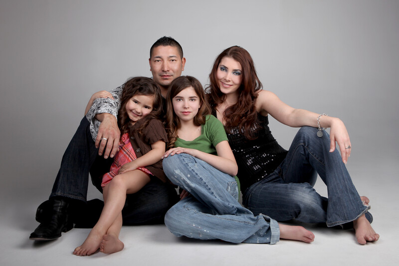 Blended family mom and dad sitting on the floor with two children