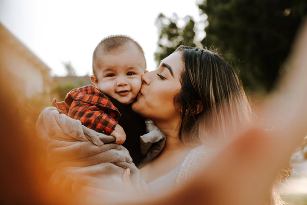 Single mom kissing her baby