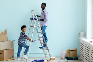 Home makeover: father and son painting walls of new home