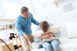 Help your teen cope with post-divorce challenges: father comforting crying son