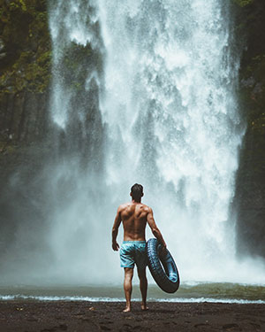 divorced man taking a vacation beside waterfall 