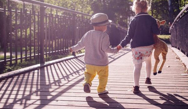 guide your kids through divorce: little boy and girl walk hand in hand