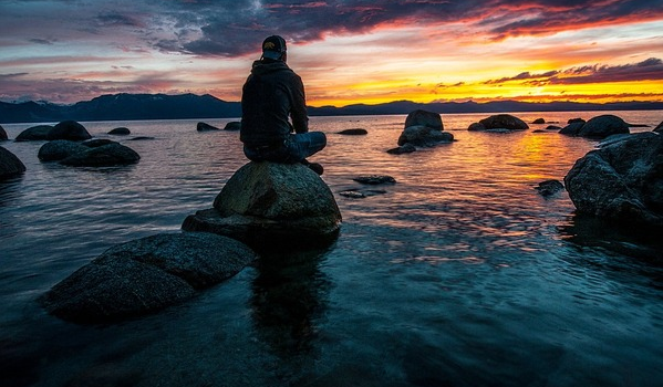 being yourself after divorce: man sits n rock and stares into ocean