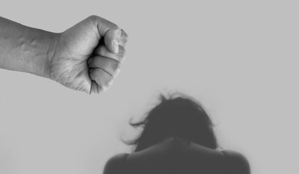 domestic violence during divorce: fist above shadow of a woman