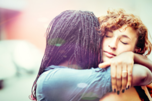 telling friends about your divorce: two female friends hugging