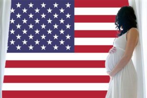 birthright citizenship: pregnant woman gazes at US flag