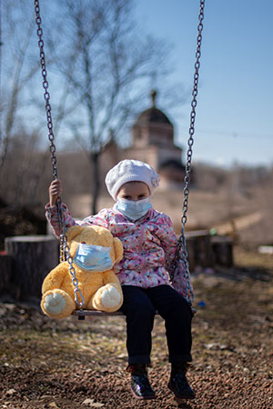 girl and her teddy bear wearing face masks during the pandemic