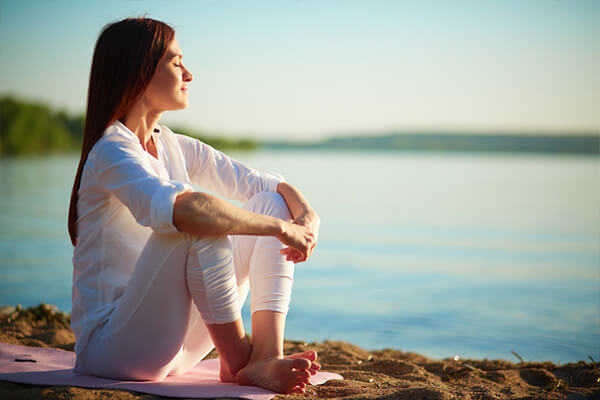 woman meditating on a beach