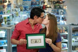 Family business: husband & wife holding a framed dollar