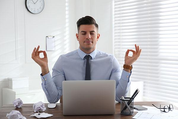 Family lawyer enjoys the benefits of meditation at his desk