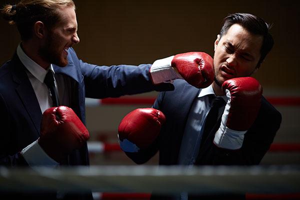 Lawyers wearing boxing gloves fight each other in a boxing ring